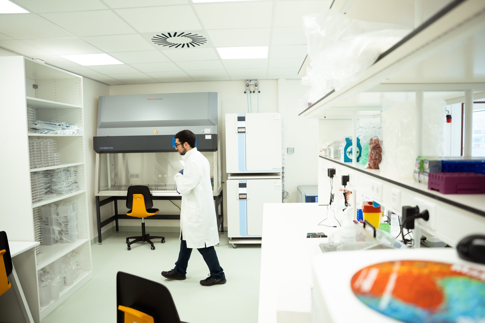 An employee at MIDA Biotech, pacing in the laboratory.