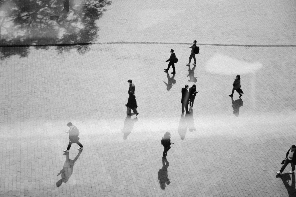 A picture from above, taken of people walking on the street.