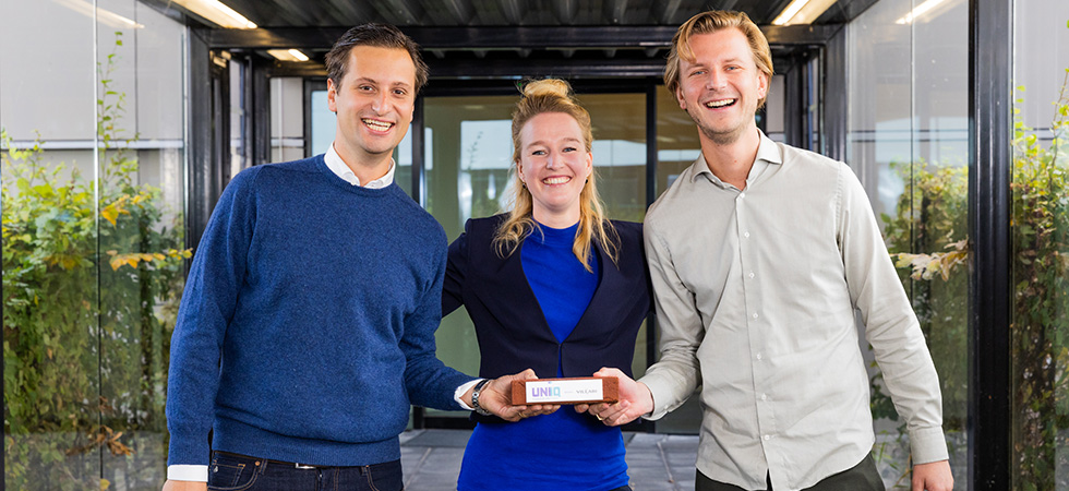 Een foto van twee Villari teamleden die de investering van UNIIQ vasthuden.