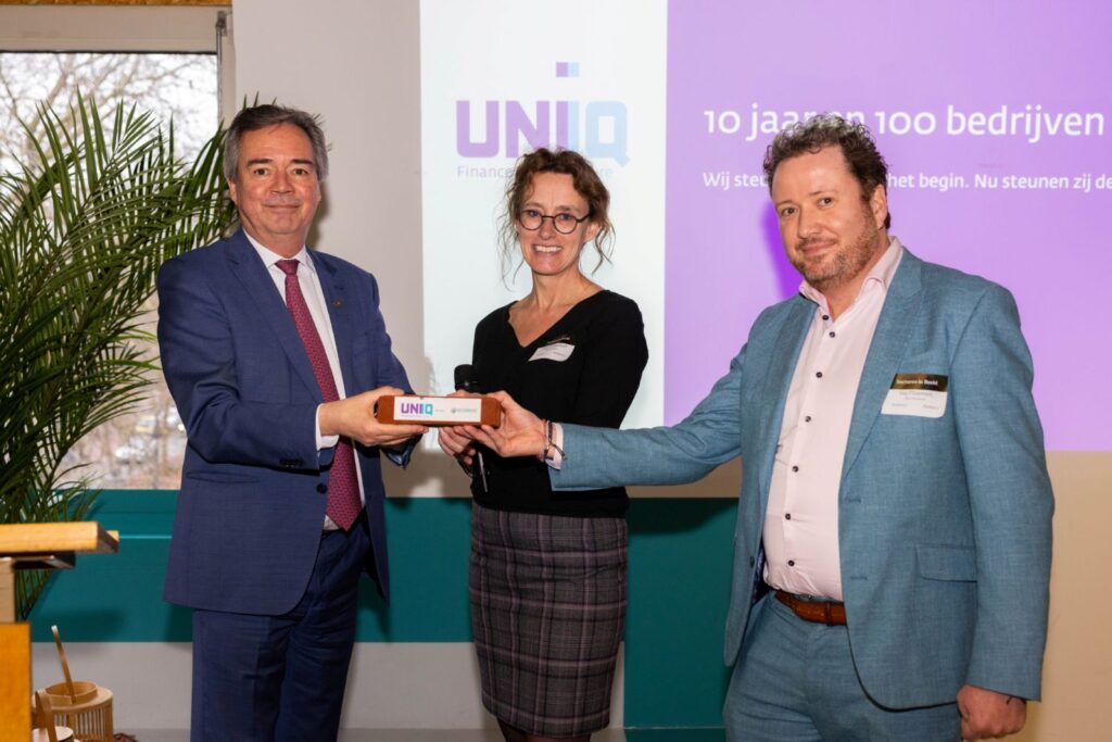 Gedeputeerde Economie en Innovatie, Provincie Zuid-Holland, Meindert Stolk overhandigt de UNIIQ baksteen aan Bactheravax; de 100e investering van UNIIQ.